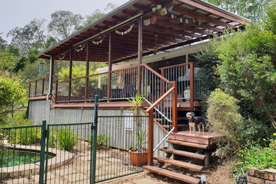 Large traditional backyard deck in Brisbane with a roof extension.