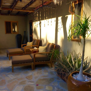Foto de terraza tropical, de tamaño medio, en patio delantero, con adoquines de hormigón y pérgola