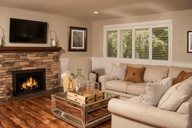 Example of a large classic open concept medium tone wood floor living room design in Seattle with beige walls, a standard fireplace, a stone fireplace and a wall-mounted tv