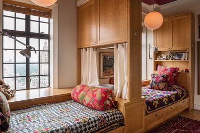 Example of an eclectic medium tone wood floor and brown floor kids' room design in New York with white walls