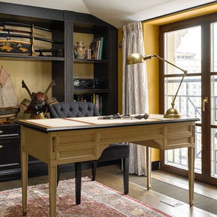 Пример оригинального дизайна интерьера: маленький рабочее место в классическом стиле с отдельно стоящим рабочим столом, желтыми стенами и паркетным полом среднего тона