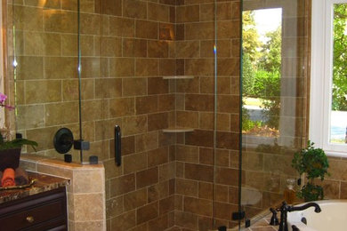 Mid-sized traditional master bathroom in Charlotte with raised-panel cabinets, dark wood cabinets, a drop-in tub, a corner shower, beige tile, porcelain tile, beige walls, porcelain floors, granite benchtops, brown floor and a hinged shower door.