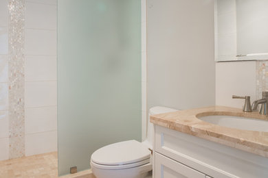 Bathroom - mid-sized contemporary master white tile and porcelain tile travertine floor and beige floor bathroom idea in Vancouver with recessed-panel cabinets, white cabinets, an undermount sink, a one-piece toilet, gray walls and onyx countertops