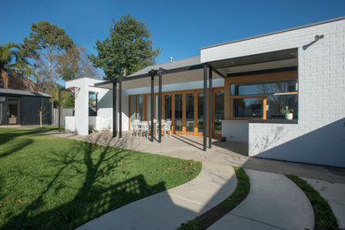 This is an example of a contemporary one-storey brick white exterior in Adelaide with a flat roof.