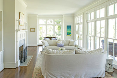Example of a mid-sized country formal and enclosed medium tone wood floor and brown floor living room design in Other with gray walls, a standard fireplace, a stone fireplace and no tv