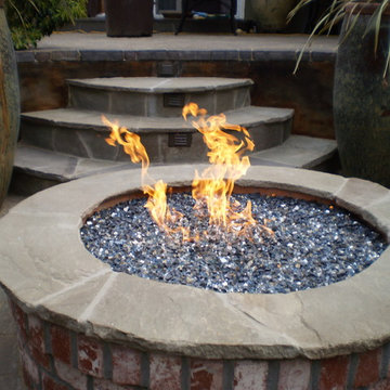 Brick fireplace with flagstone cap and beautiful planted pots