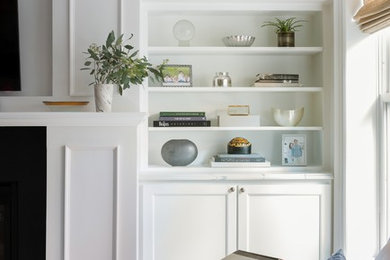 Inspiration for a mid-sized transitional open concept medium tone wood floor and brown floor living room remodel in Boston with a wall-mounted tv, gray walls and a standard fireplace