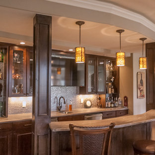 Diseño de sótano con puerta clásico renovado, grande, con paredes beige, suelo de baldosas de porcelana, chimenea tradicional y marco de chimenea de piedra