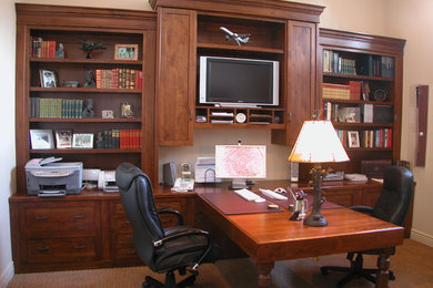 Mid-sized traditional study room in Other with beige walls, carpet, no fireplace and a built-in desk.