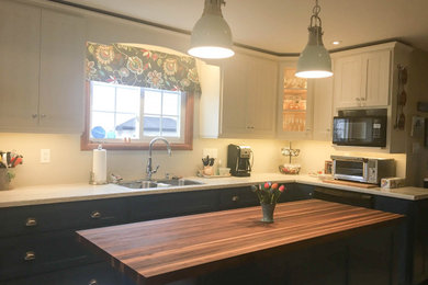 Inspiration for a mid-sized country u-shaped porcelain tile and beige floor eat-in kitchen remodel in Other with a drop-in sink, white cabinets, wood countertops, white backsplash, an island, recessed-panel cabinets, stainless steel appliances and brown countertops