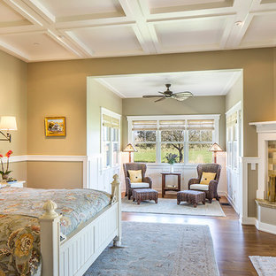 Großes Country Schlafzimmer mit beiger Wandfarbe, braunem Holzboden, Eckkamin und gefliester Kaminumrandung in Santa Barbara