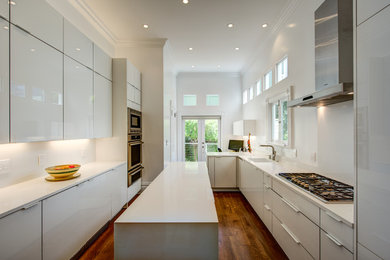 Mid-sized contemporary galley separate kitchen in San Francisco with a drop-in sink, flat-panel cabinets, white cabinets, white splashback, medium hardwood floors and with island.