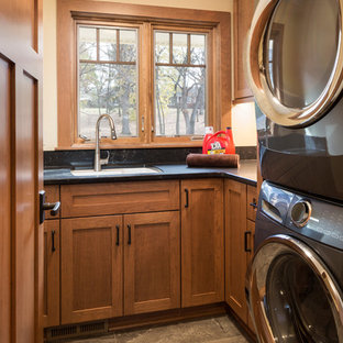 ミネアポリスの中サイズのおしゃれな洗濯室 (アンダーカウンターシンク、落し込みパネル扉のキャビネット、中間色木目調キャビネット、クオーツストーンカウンター、ベージュの壁、上下配置の洗濯機・乾燥機、緑の床) の写真