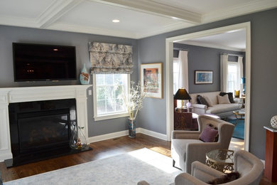 This is an example of a transitional open concept family room in New York with grey walls, dark hardwood floors, a standard fireplace, a plaster fireplace surround and a wall-mounted tv.