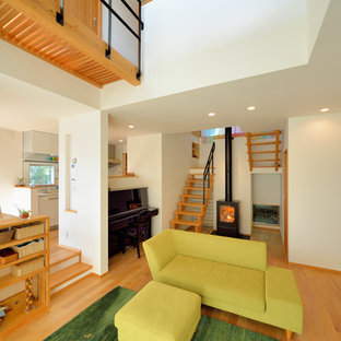 Ispirazione per un piccolo soggiorno etnico con pavimento in legno massello medio, stufa a legna, pareti bianche e pavimento beige