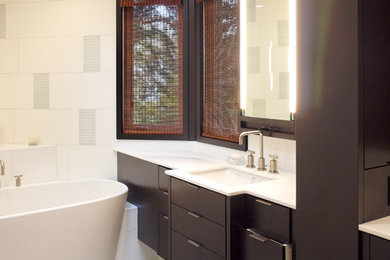 Inspiration for a large contemporary master glass tile limestone floor freestanding bathtub remodel in Chicago with flat-panel cabinets, brown cabinets, a two-piece toilet, white walls, an undermount sink and marble countertops