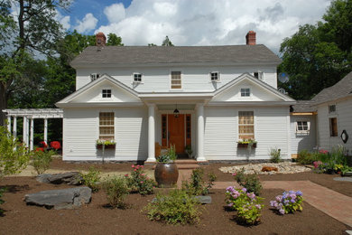 This is an example of a large country two-storey white house exterior in New York with a gable roof and a shingle roof.