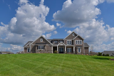 Inspiration for a timeless brown two-story mixed siding exterior home remodel with a shingle roof and a black roof