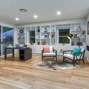 Inspiration for an expansive contemporary study room in Brisbane with grey walls, light hardwood floors, a ribbon fireplace and a freestanding desk.