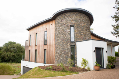 Inspiration for a large and multi-coloured contemporary house exterior in Other with three floors, mixed cladding, a flat roof and a mixed material roof.