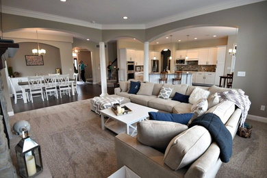 Inspiration for a mid-sized timeless formal and open concept carpeted living room remodel in Other with beige walls, a standard fireplace, a stone fireplace and a wall-mounted tv