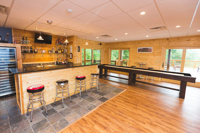 Basement - large rustic walk-out medium tone wood floor basement idea in Nashville with brown walls