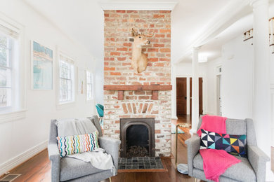 Living room - mid-sized eclectic open concept medium tone wood floor living room idea in Atlanta with white walls, a two-sided fireplace, a brick fireplace and a tv stand
