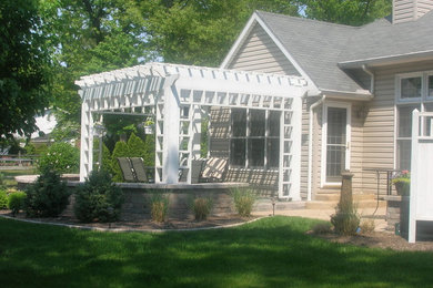 Foto de patio moderno de tamaño medio en patio trasero con adoquines de hormigón, brasero y pérgola
