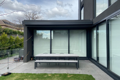 Design ideas for a large contemporary courtyard patio in Melbourne with an awning.
