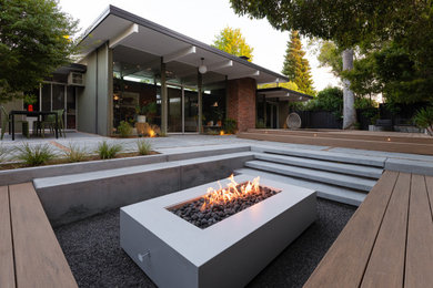 Example of a small minimalist backyard gravel patio design in Richmond with a fire pit and a pergola