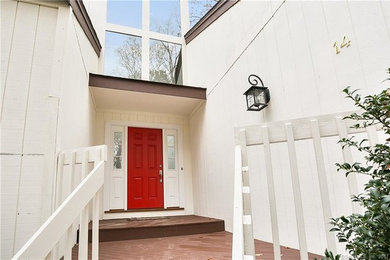 This is an example of a mid-sized traditional front door in New York with red walls, a single front door and a red front door.