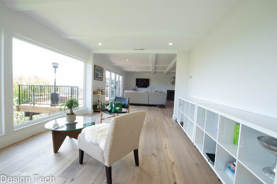 Inspiration for a mid-sized modern open concept medium tone wood floor and brown floor living room remodel in Los Angeles with white walls, a standard fireplace, a tile fireplace and a wall-mounted tv