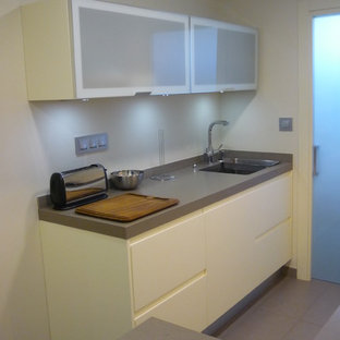 Transitional kitchen pantry appliance - Example of a transitional u-shaped porcelain floor kitchen pantry design in Barcelona with a double-bowl sink, beaded inset cabinets, beige cabinets, solid surface countertops, gray backsplash and no island
