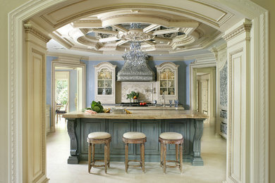 Large elegant u-shaped limestone floor eat-in kitchen photo in New York with a farmhouse sink, beaded inset cabinets, beige cabinets, limestone countertops, beige backsplash, mosaic tile backsplash, black appliances and two islands