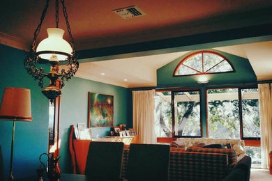 Photo of a mid-sized midcentury enclosed family room in Canberra - Queanbeyan with green walls, carpet and no fireplace.