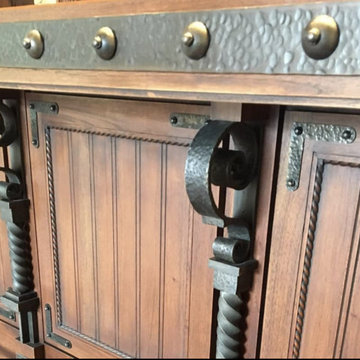 We are designers and builders of carved wood doors with wrought metal appliqués.