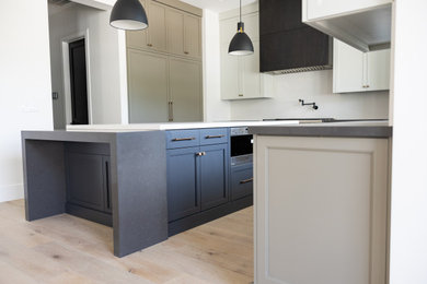 Large transitional galley open concept kitchen photo in Phoenix with an integrated sink, recessed-panel cabinets, gray cabinets, marble countertops, white backsplash, marble backsplash, paneled appliances, an island and white countertops