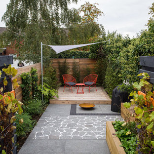 Moderner Patio mit Kübelpflanzen, Dielen und Markisen in Manchester