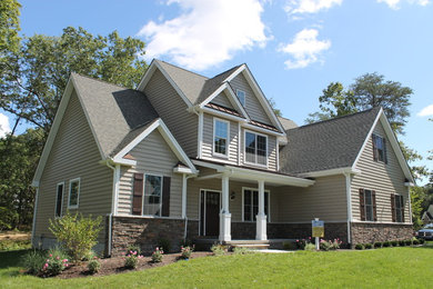 Example of a mid-sized classic beige two-story mixed siding exterior home design in Other with a hip roof