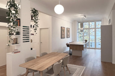 Mittelgroße Skandinavische Wohnküche mit weißer Wandfarbe, hellem Holzboden und braunem Boden in Berlin