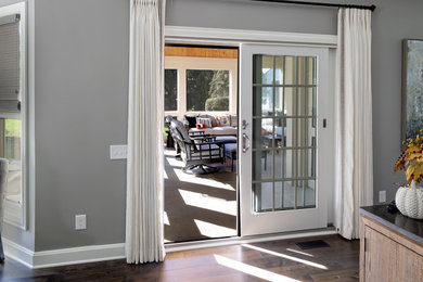 Inspiration for a mid-sized timeless stamped concrete screened-in and wood railing back porch remodel in Columbus with a roof extension