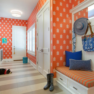 Ejemplo de lavadero multiusos y de galera, clásico, con armarios con paneles empotrados, puertas de armario blancas, parades naranjas y lavadora y secadora juntas