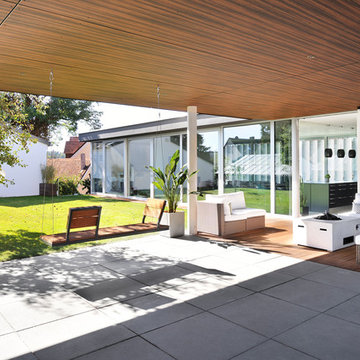 Überdachte Terrasse mit Loungemöbel und Feuerstelle