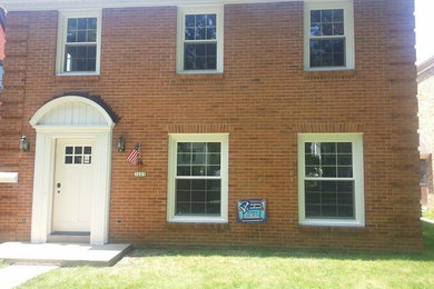 Example of a mid-sized classic red two-story brick exterior home design in Milwaukee