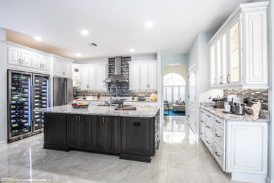 Example of a large transitional u-shaped porcelain tile and beige floor eat-in kitchen design in Orlando with a double-bowl sink, raised-panel cabinets, white cabinets, quartz countertops, metallic backsplash, mosaic tile backsplash, an island and beige countertops