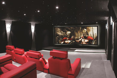 Modelo de cine en casa contemporáneo con paredes negras, moqueta y suelo gris