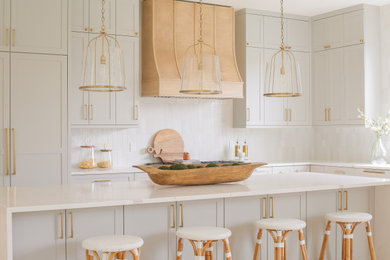 Open concept kitchen - large coastal l-shaped light wood floor and brown floor open concept kitchen idea in Seattle with a drop-in sink, shaker cabinets, gray cabinets, quartz countertops, gray backsplash, subway tile backsplash, paneled appliances, an island and white countertops