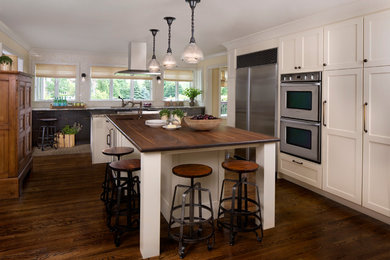 Kitchen - rustic medium tone wood floor kitchen idea in Detroit with white cabinets, stainless steel appliances and an island