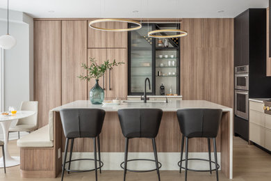 Open concept kitchen - mid-sized contemporary l-shaped light wood floor open concept kitchen idea in Toronto with an undermount sink, flat-panel cabinets, quartz countertops, quartz backsplash, stainless steel appliances and an island