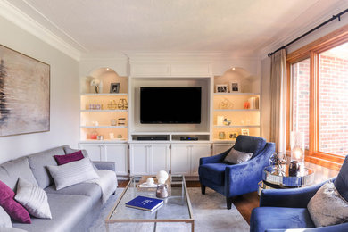 Inspiration for a mid-sized transitional formal and enclosed medium tone wood floor living room remodel in Toronto with gray walls, no fireplace and a media wall